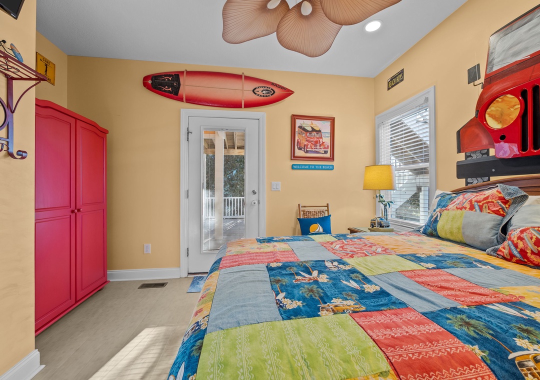 Your vibrant beach-themed bedroom features surf decor, colorful quilts, and tropical ceiling fans for the perfect coastal getaway vibe.