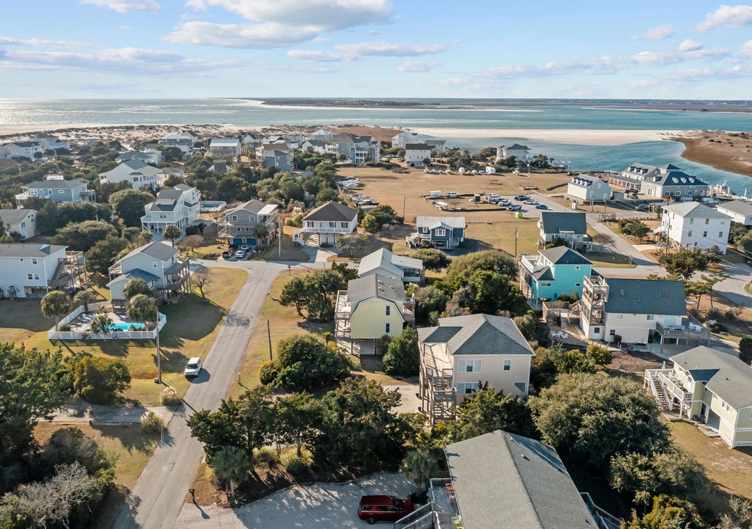 Stunning aerial view reveals a charming beach community with pristine shores and turquoise waters just steps away from comfortable coastal homes.