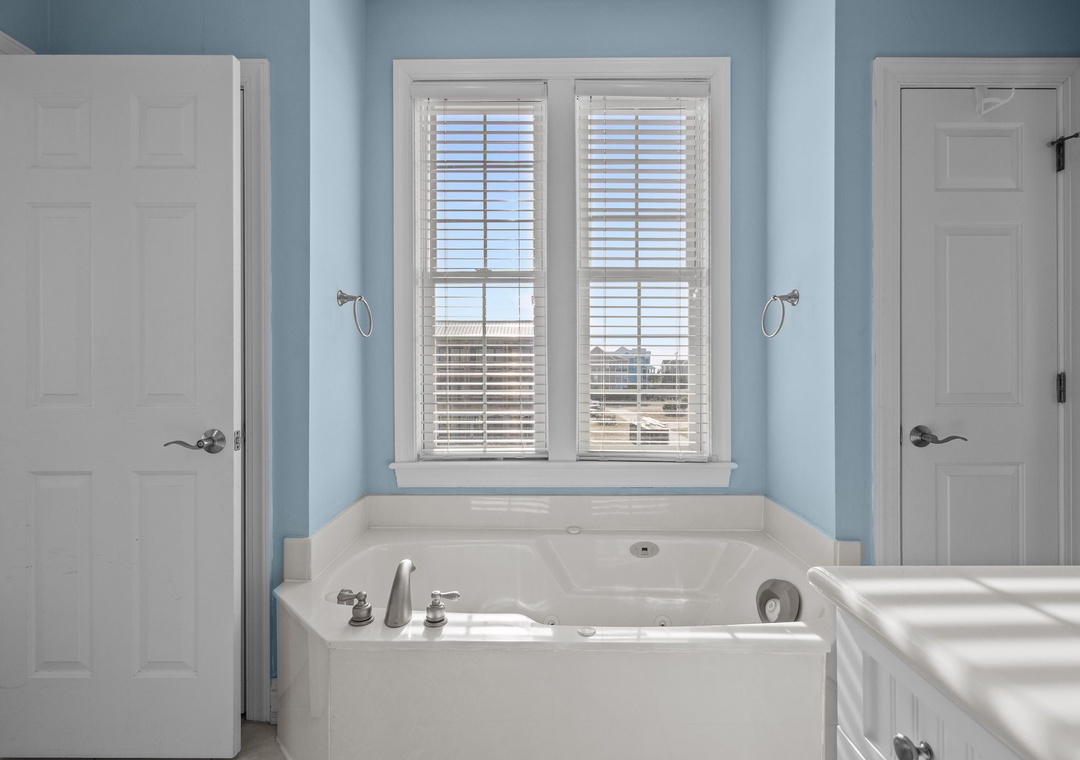 Soak away your worries in this spacious master bathroom tub, perfectly positioned beneath windows for natural light during your relaxing retreat.