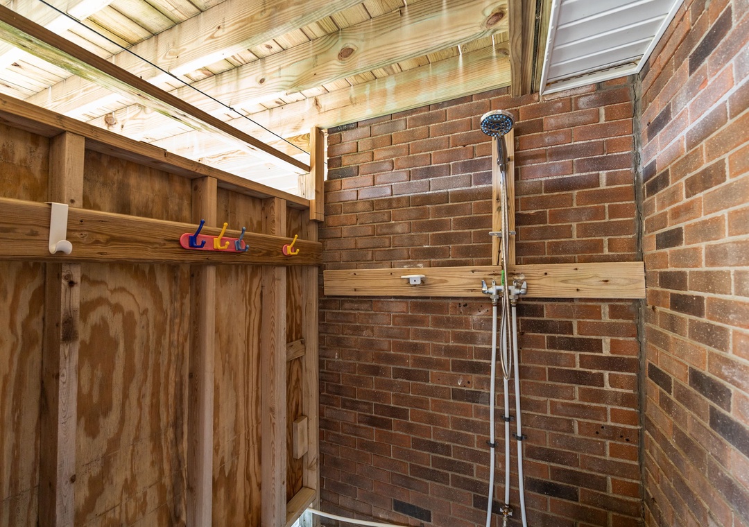 Rinse off under your private outdoor shower, surrounded by warm brick walls and natural wood—perfect after beach days or hikes.