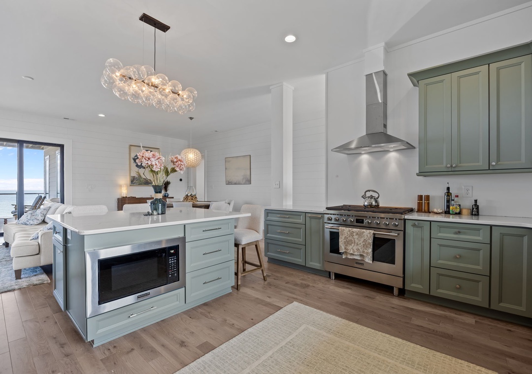 Your gourmet kitchen features premium appliances and elegant sage cabinetry, perfect for creating memorable meals in this light-filled space.