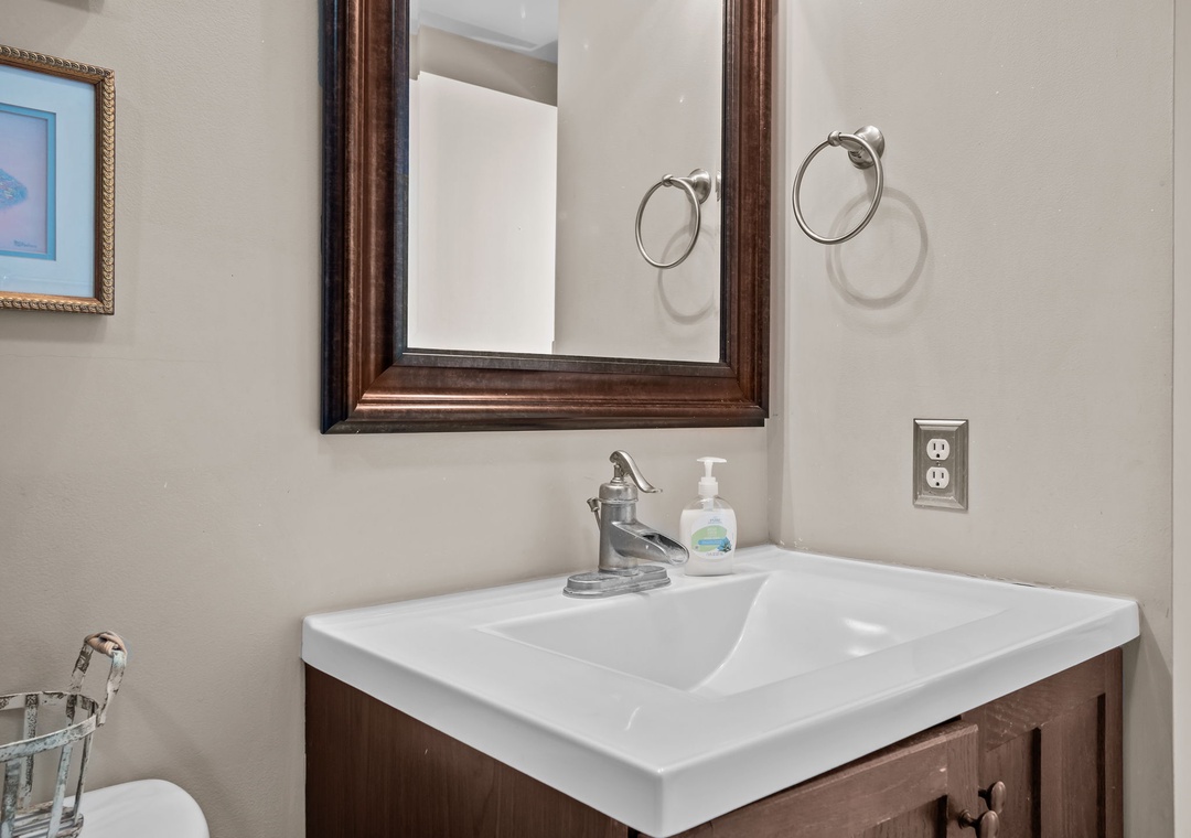 Refresh in your private bathroom featuring a spacious vanity, elegant bronze-framed mirror, and thoughtful touches like complimentary soap.