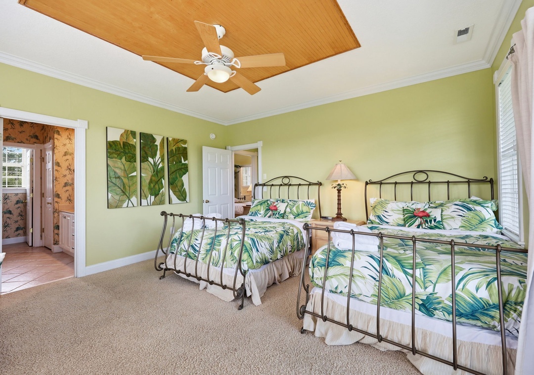 Drift off in your tropical-themed bedroom with two plush beds, botanical artwork, and a warm wooden ceiling fan keeping you comfortable all night.