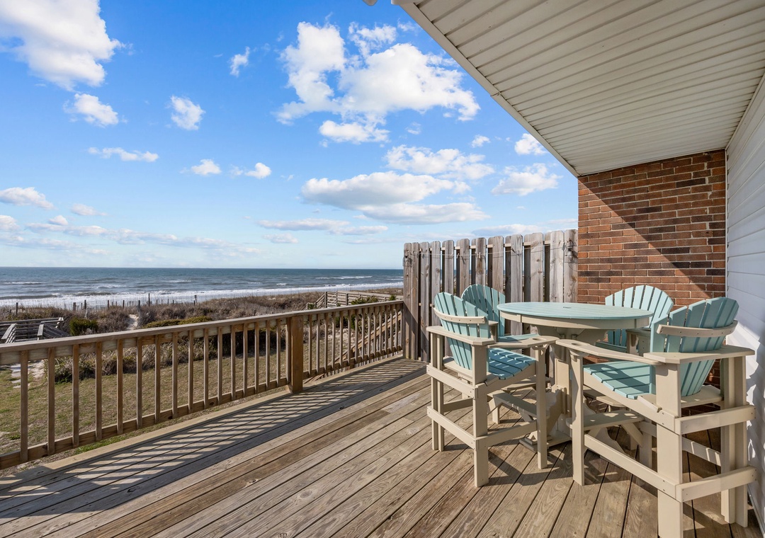 Your private deck overlooks pristine beach where ocean waves meet sandy shores, creating the perfect backdrop for morning coffee or sunset dining.