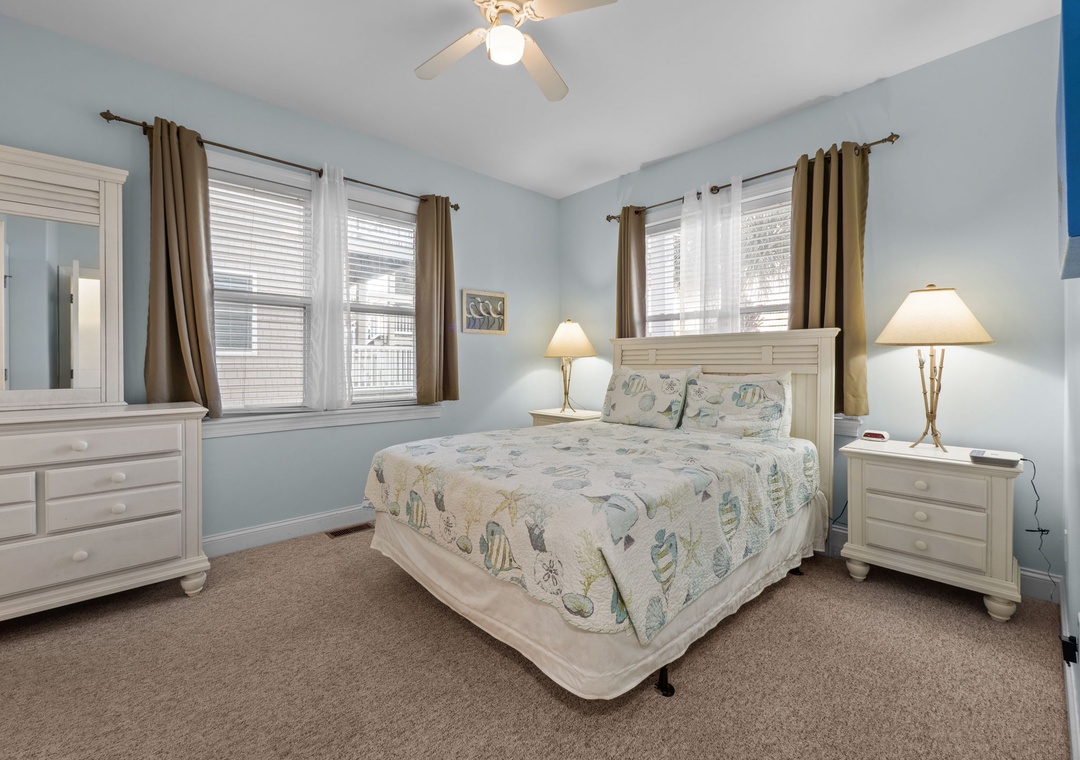 Your peaceful bedroom retreat features soft blue walls, elegant white furniture, and coastal-themed bedding to ensure you wake up refreshed.