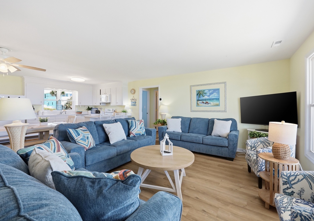 Sink into these plush blue sofas with your favorite book after a day of beach adventures. The open layout flows effortlessly into the kitchen and dining space, perfect for sharing meals and making memories together.