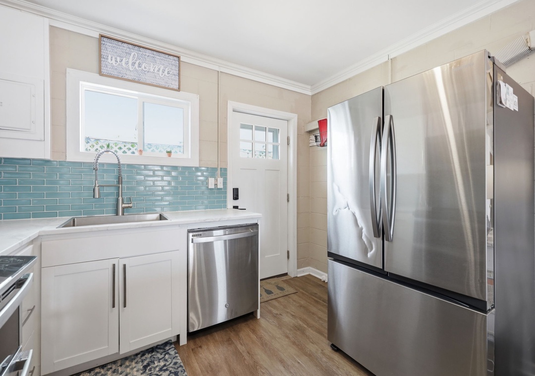 Your bright, beachy kitchen welcomes you with coastal charm—soft blues, gleaming appliances, and warm wood floors make cooking feel like a vacation in itself.