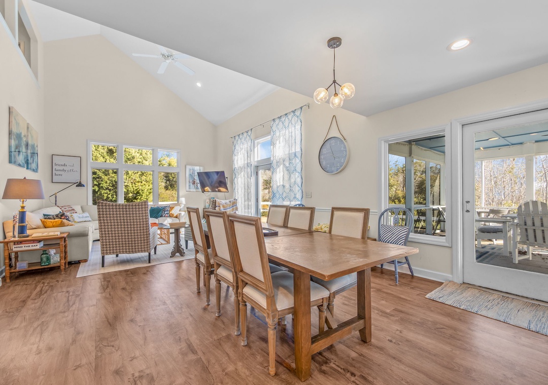 Gather around the warm wooden table where meals become memories, with natural light streaming through windows and seamless patio access.