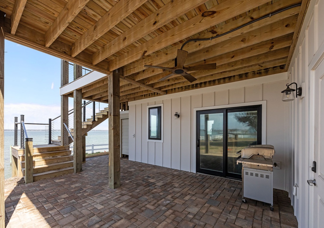 Your private covered deck offers stunning waterfront BBQ moments with rustic wood beams overhead and ocean views stretching endlessly ahead.