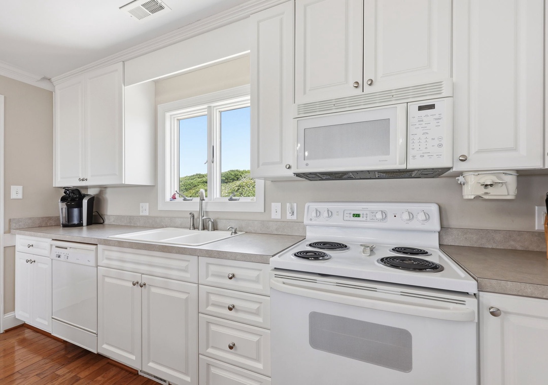 Bright, fully-equipped kitchen with everything you need to whip up your favorite meals, complete with coffee maker and natural light streaming through the window.