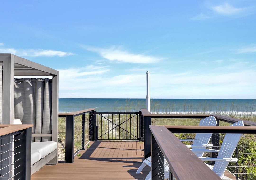 Step onto your private deck and breathe in the coastal air. Comfortable seating awaits as you gaze across natural dunes to the serene sea beyond.