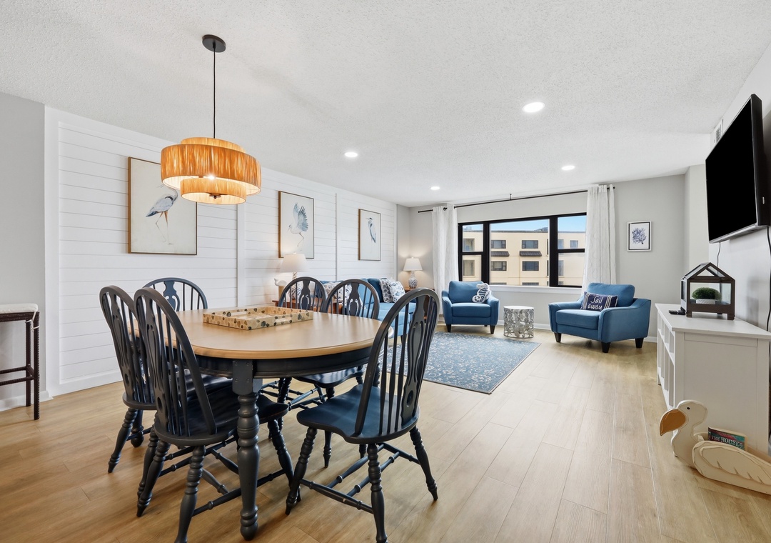 Gather around the dining table or relax in the cozy living area—this open, sunlit space invites you to unwind, share meals, and make memories together in comfort and style.