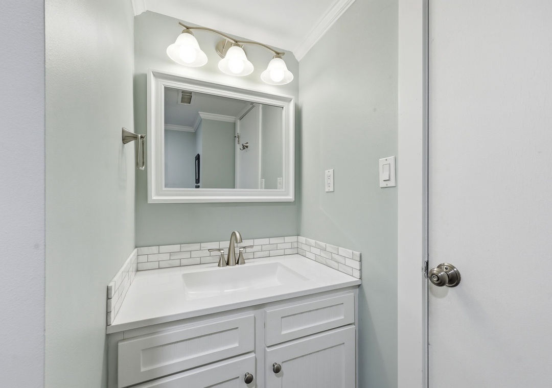 Your bright, beautifully updated bathroom features a crisp white vanity, subway tile accents, and soothing mint walls that create a fresh, spa-like retreat for your morning routine.
