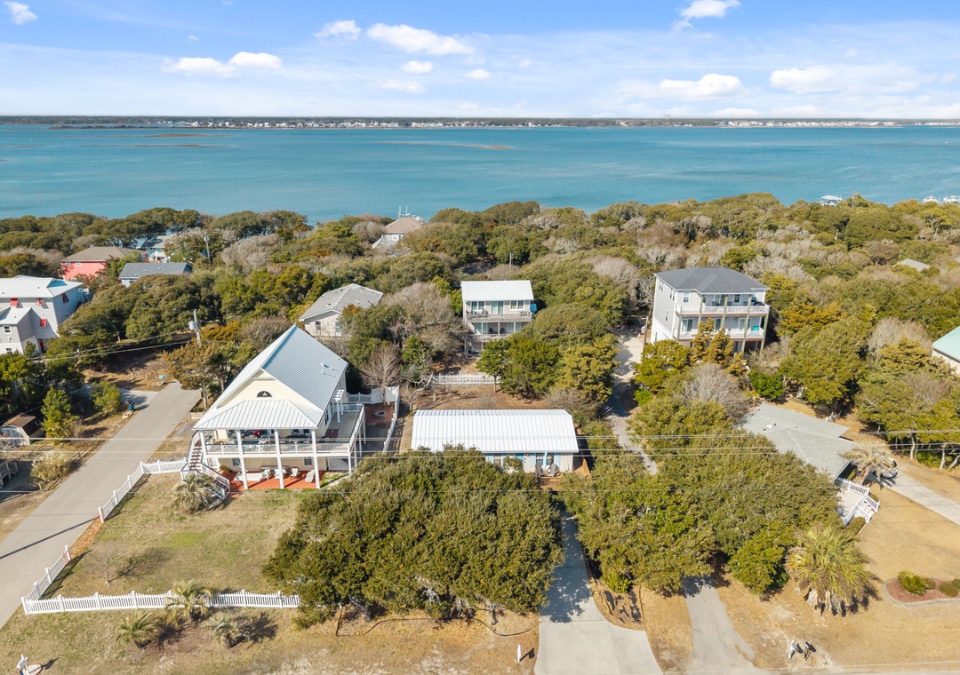 Coastal properties nestled among mature trees offer proximity to pristine turquoise waters and peaceful residential surroundings.