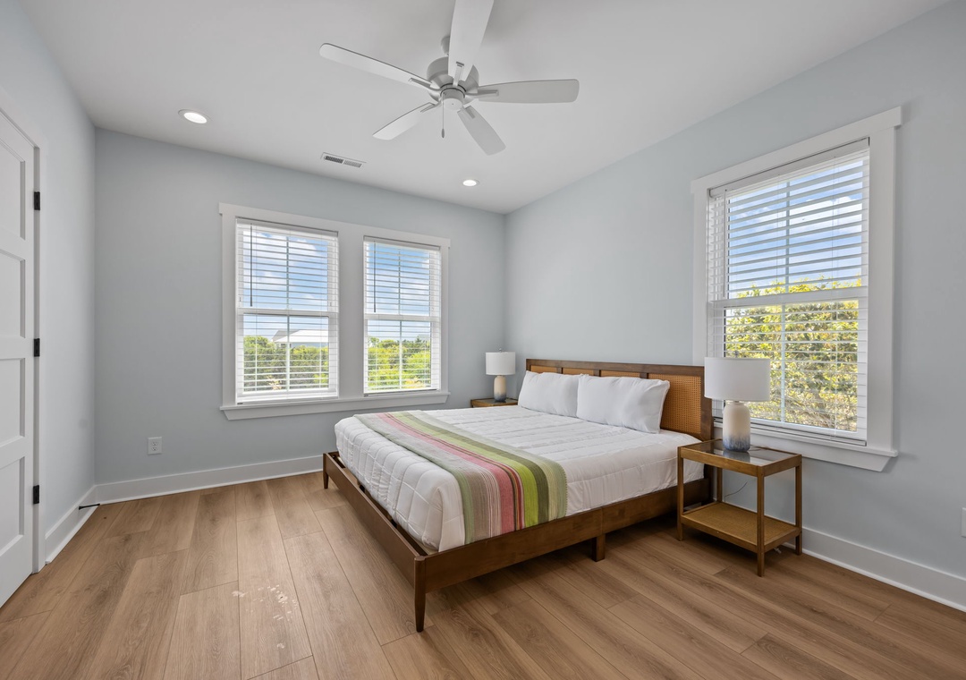 Drift off in your serene bedroom with crisp linens, warm wood floors, and natural light streaming through bright windows.