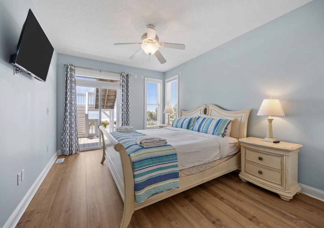 Drift off in your serene coastal bedroom with calming blue walls, crisp linens, and ocean breezes flowing through your private balcony.