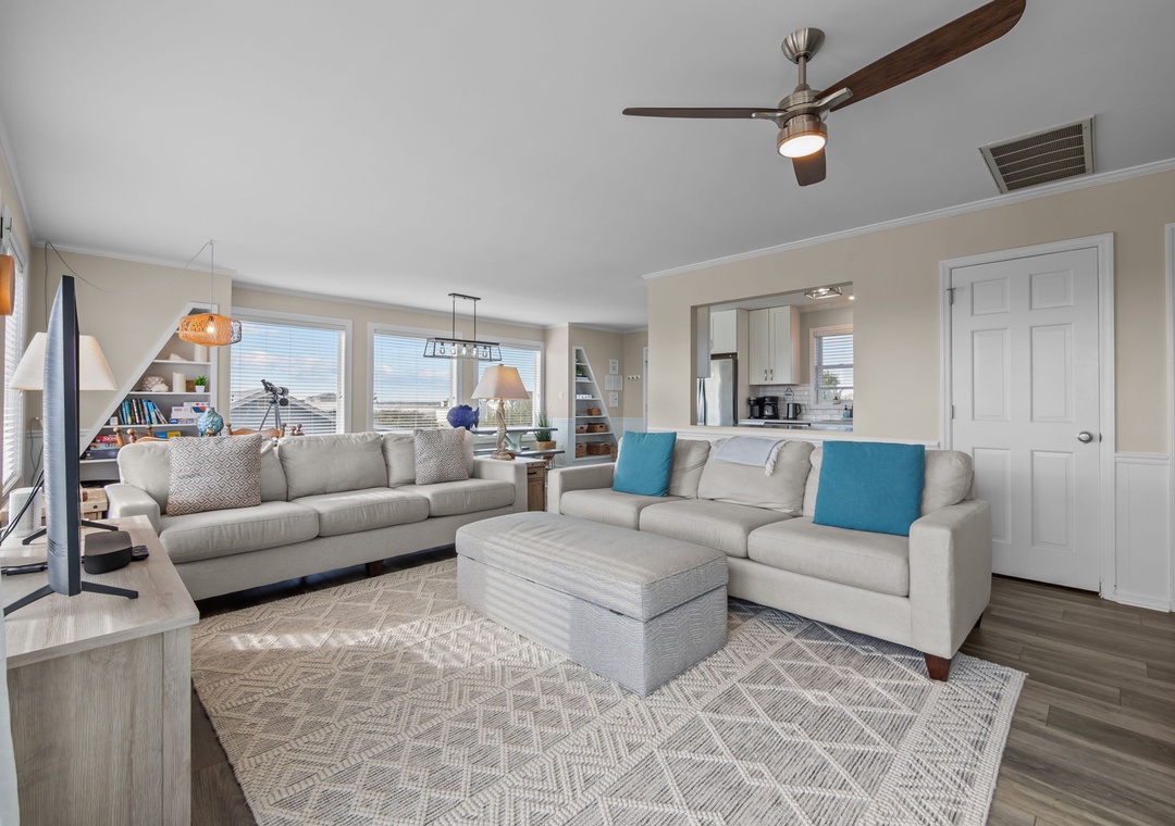 Settle into plush sectional seating with turquoise accents as gentle ceiling fans circulate cool air through your bright, open living space.