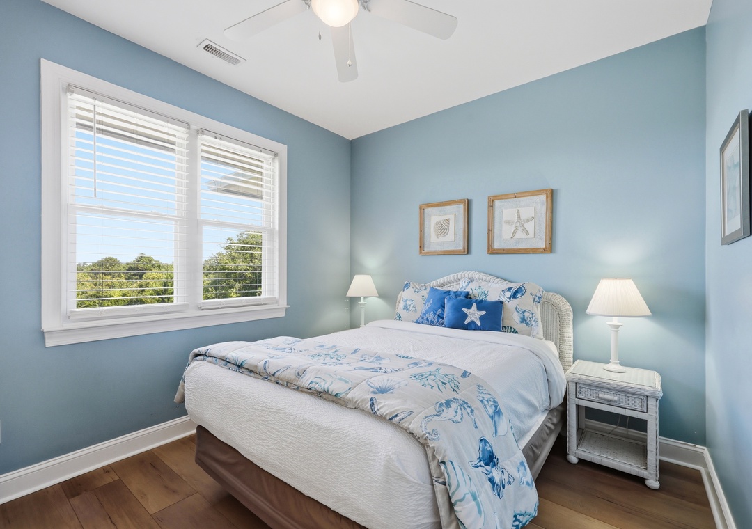 Drift off in this serene coastal bedroom where soft blue walls and ocean-themed touches create your perfect seaside escape. Fresh breezes and natural light complete the tranquil atmosphere.