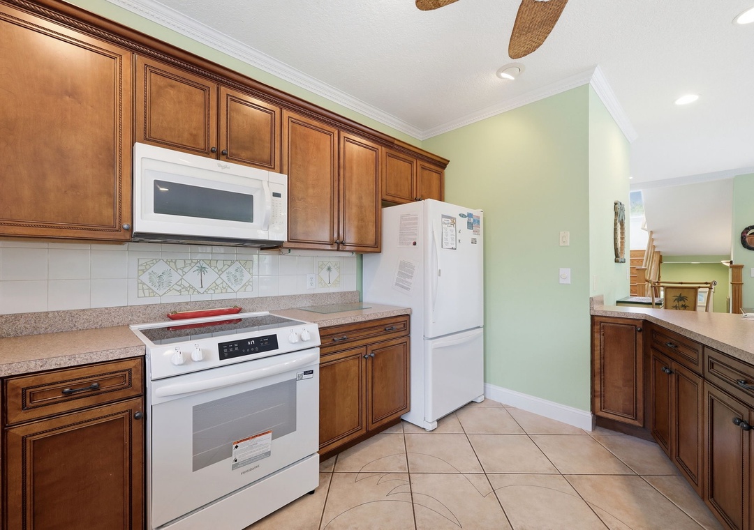 Your kitchen awaits with warm wood cabinetry, modern appliances, and spacious counters—perfect for preparing meals and gathering with loved ones during your stay.
