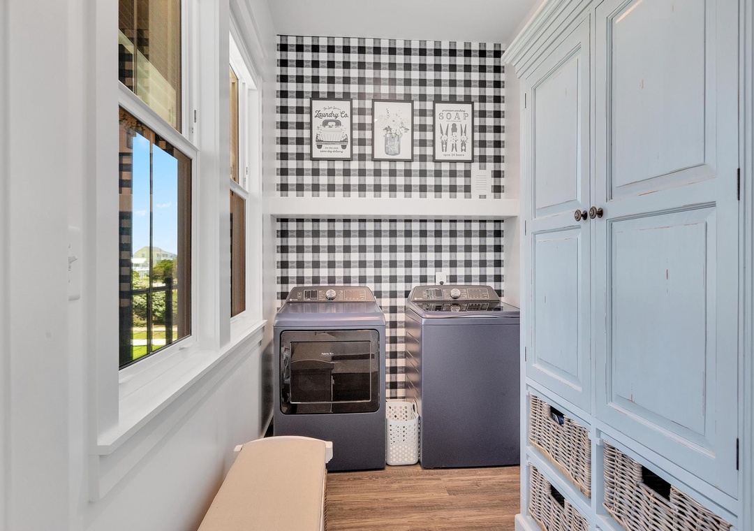 Your dedicated laundry room features a modern washer and dryer set, stylish gingham accent wall, and plenty of natural light to make chores a breeze.