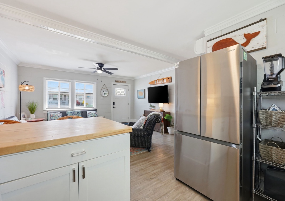 Step into your bright, open living space where coastal charm meets modern comfort. Relax on the cozy sofa, whip up meals at the sleek kitchen island, and enjoy easy access to everything you need for a perfect beach getaway.