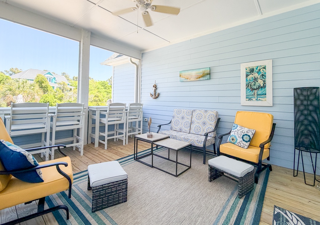 Unwind on your private screened porch with coastal charm—plush seating, a ceiling fan, and a dining table for morning coffee or evening relaxation with a breeze.
