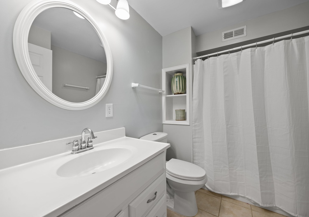 Step into your pristine bathroom featuring fresh linens, elegant fixtures, and thoughtful built-in storage for all your essentials.