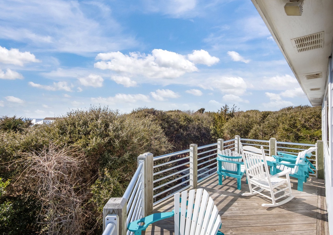 Spacious deck overlooking natural coastal vegetation with comfortable seating for outdoor relaxation.