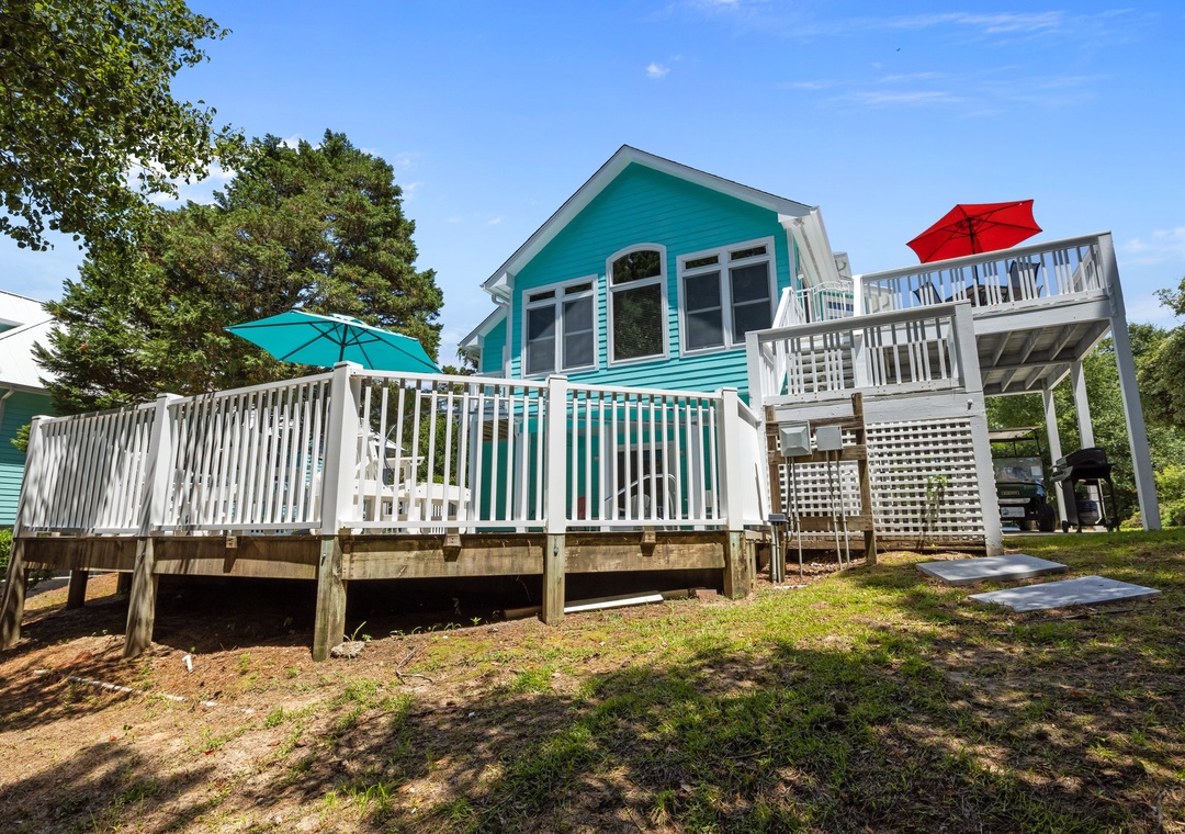 Charming turquoise cottage with spacious decks and outdoor amenities set among mature trees.