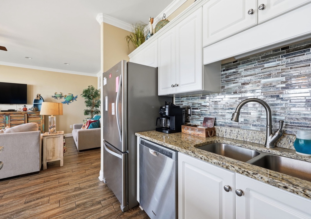 Your fully equipped kitchen flows seamlessly into a bright living area, where gleaming granite counters and a stylish backsplash make meal prep a pleasure.