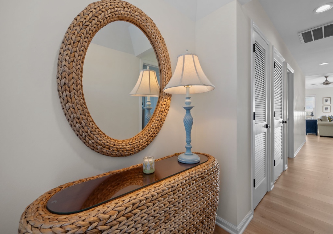 Step into your stylish entryway featuring coastal-inspired wicker furnishings and warm ambient lighting that welcomes you home.