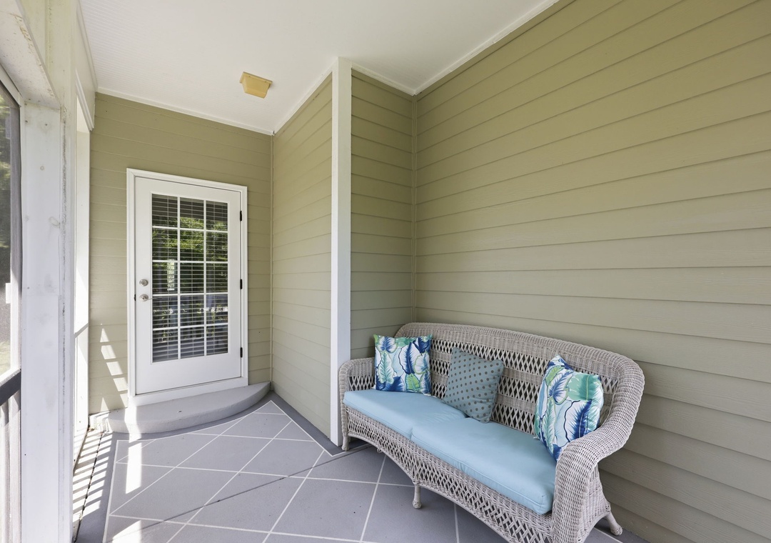 Step onto your private porch and sink into the cozy wicker sofa—a perfect spot to enjoy morning coffee or unwind after exploring the area.