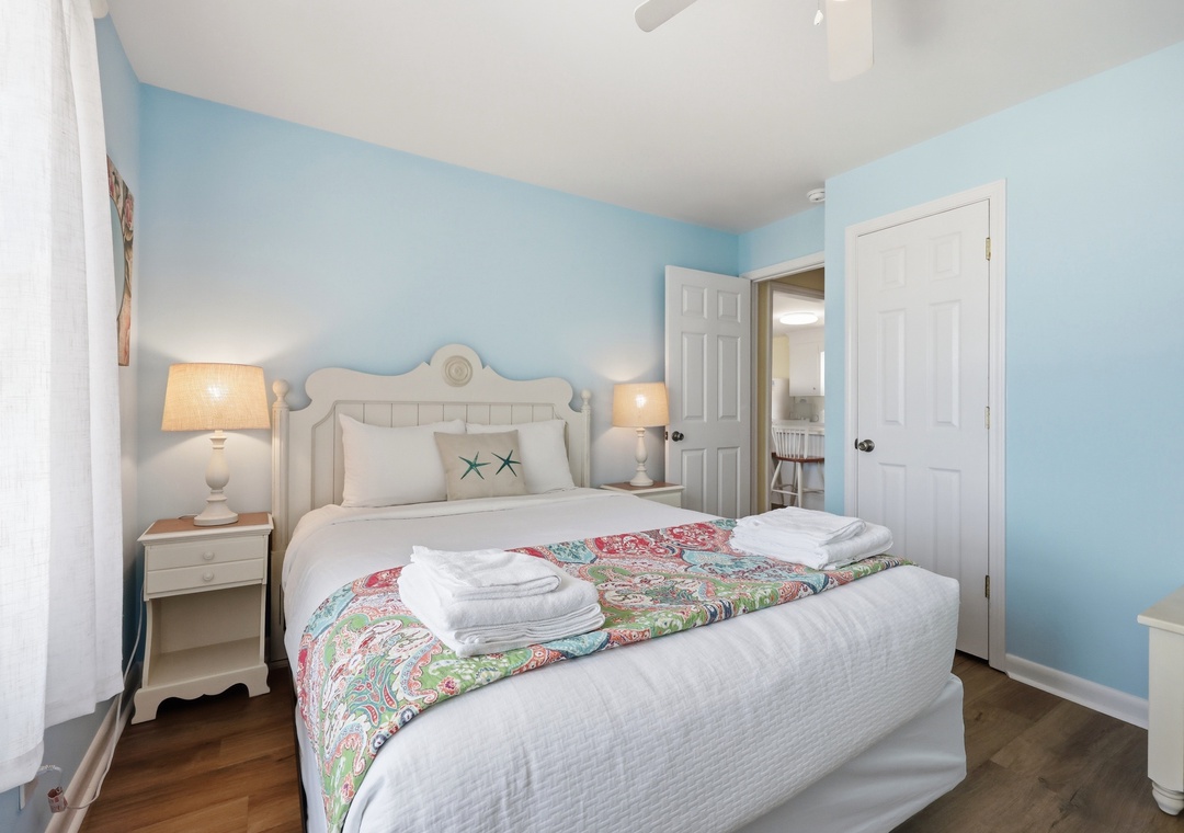 Step into your peaceful coastal retreat with soft blue walls, starfish accents, and crisp linens inviting you to unwind after a day at the beach.