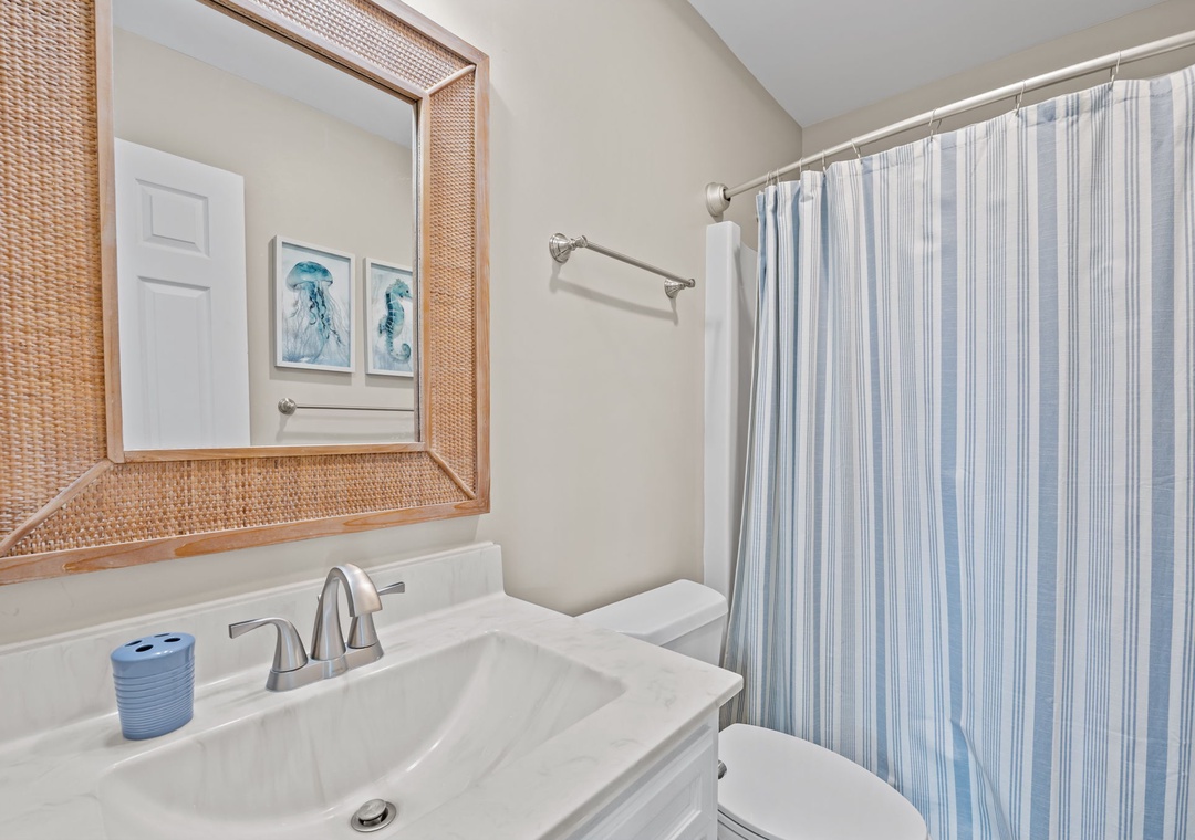 Step into your private bathroom featuring coastal-inspired décor with natural textures and soothing blue accents for a refreshing start to your day.