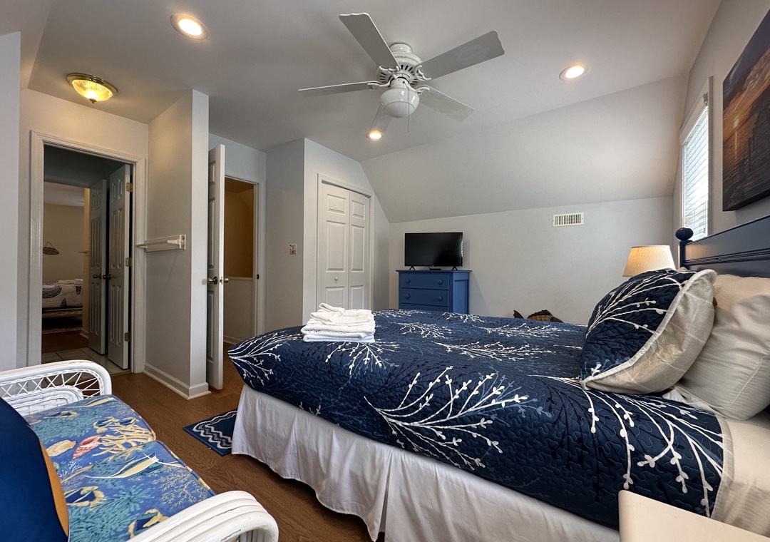 Relax in your serene bedroom with calming navy and white linens, a ceiling fan to keep you cool, and your own TV for unwinding after a day of exploring.
