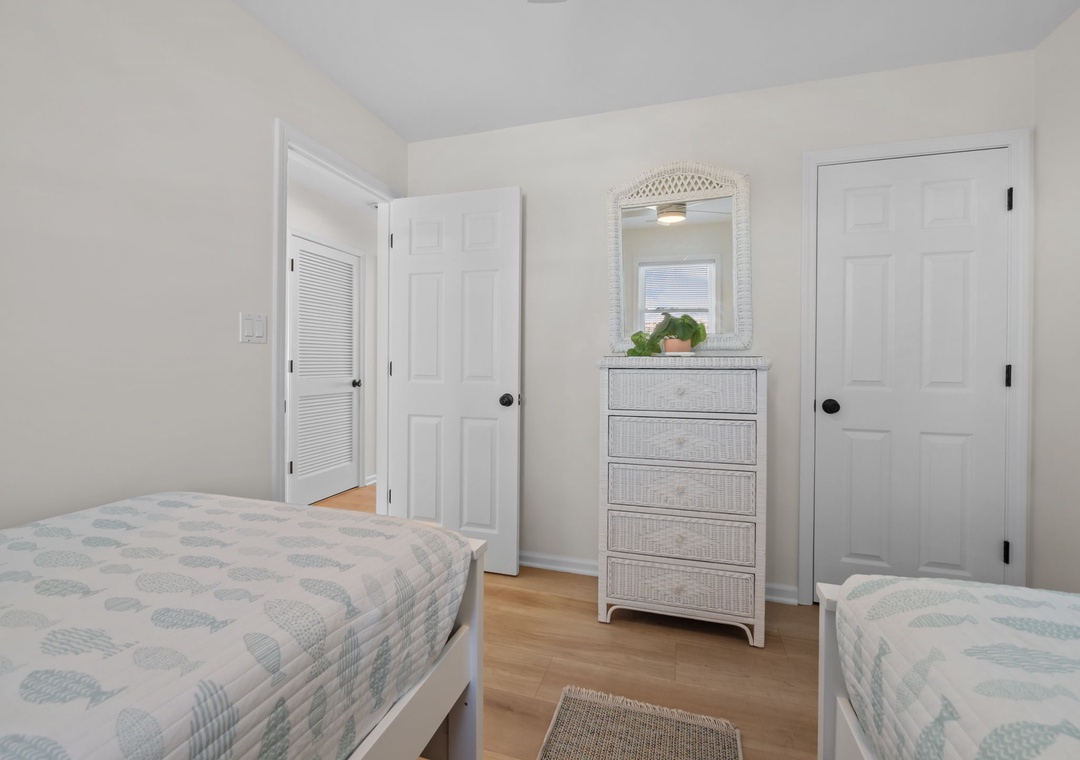Your peaceful twin bedroom features soft coastal linens and ample storage, creating a serene retreat for restful nights.