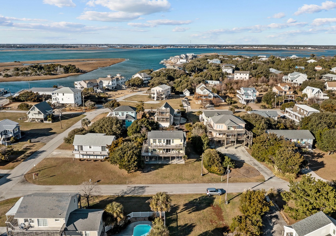 Aerial view of a coastal residential community with waterfront access and nearby beach areas.