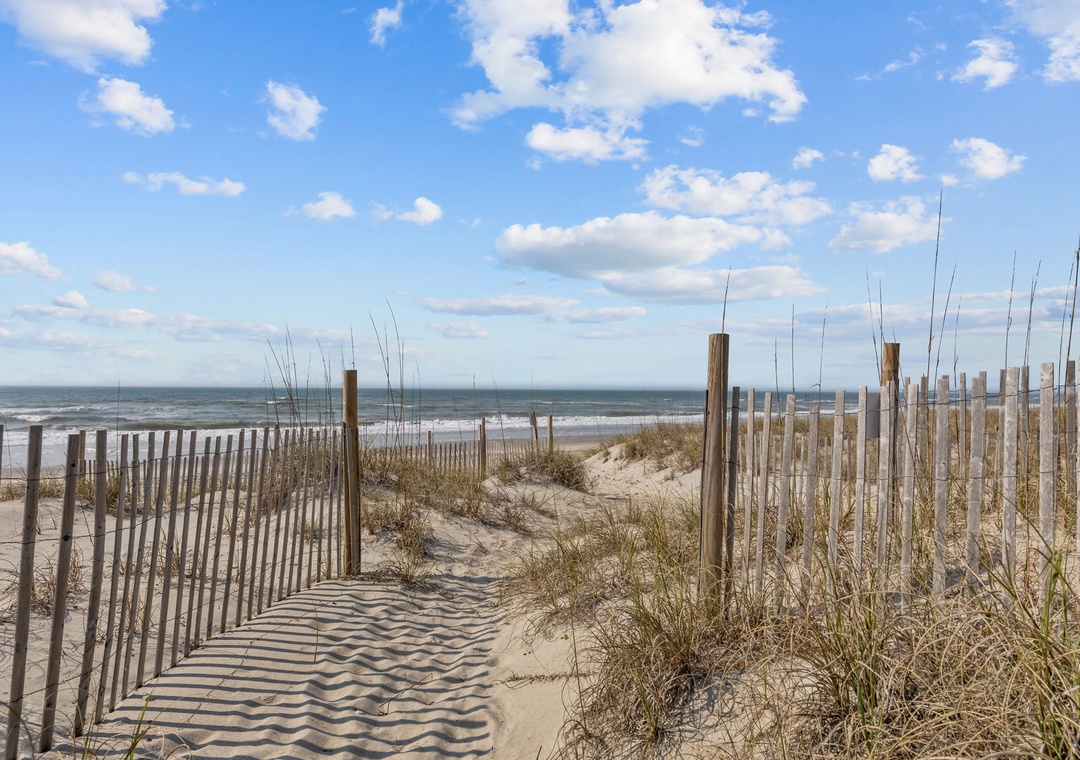 Pristine beach access with dunes and wooden walkway leading to the ocean.