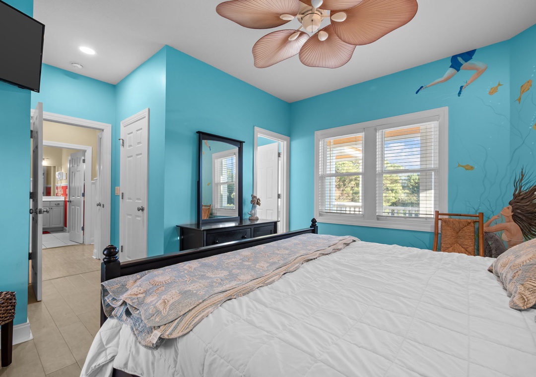 Drift to sleep in your ocean-themed bedroom with turquoise walls and tropical ceiling fan creating gentle breezes.