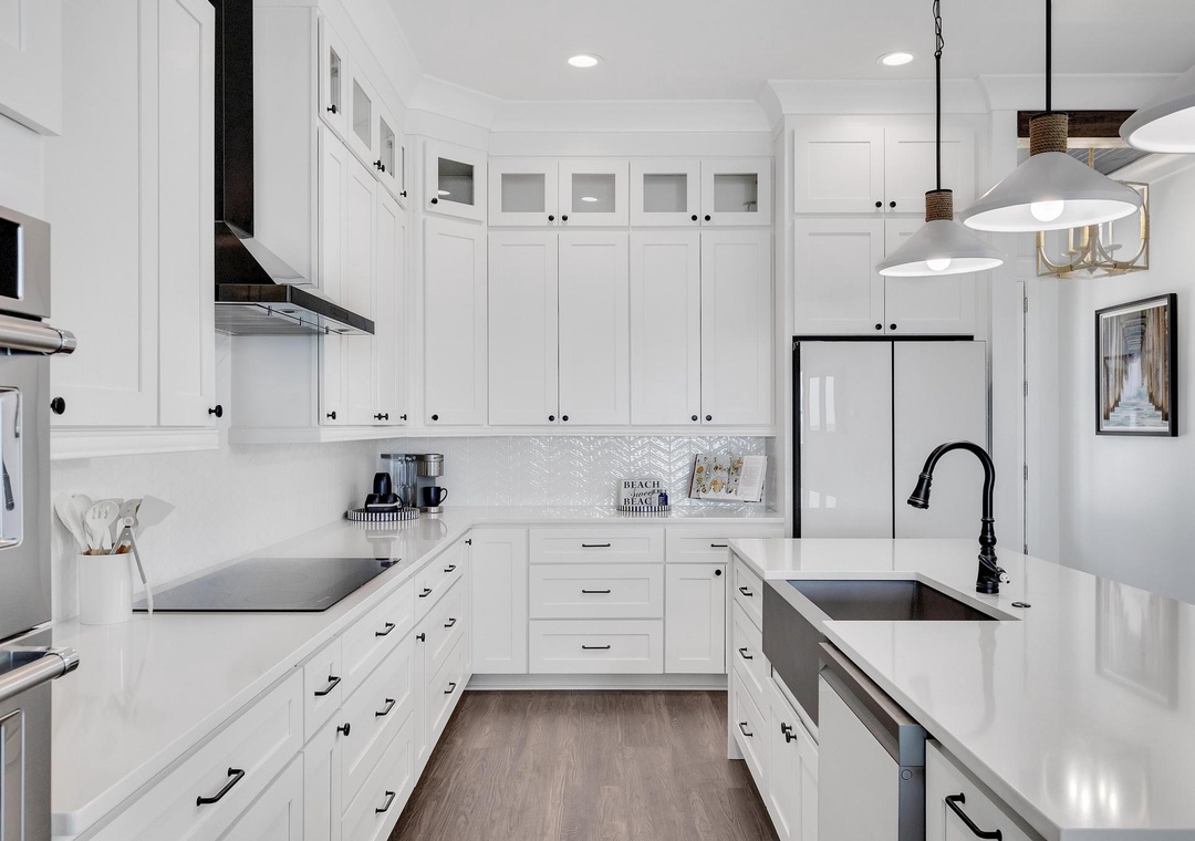 Step into your fully-equipped gourmet kitchen, where bright white cabinetry, sleek countertops, and modern appliances invite you to create delicious meals in a space that feels both elegant and welcoming.