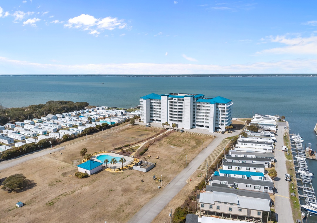 Stunning aerial view of waterfront property nestled between pristine coastline and peaceful marina surroundings.