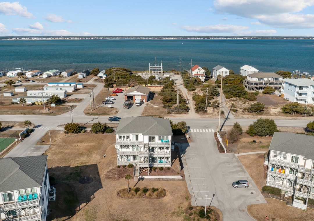 Coastal community with vacation homes nestled between sound waters and oceanfront, offering peaceful retreat near pristine beaches.