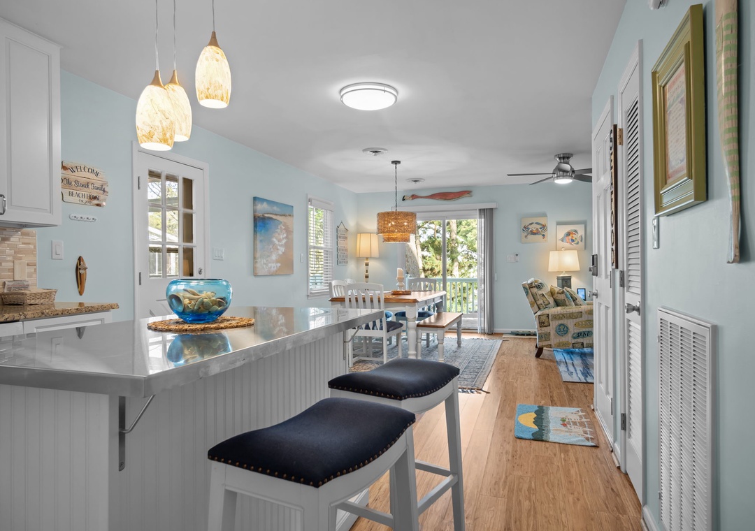 Your coastal-inspired open-concept space flows from kitchen to dining to living, perfect for gathering with beach-themed charm and modern comfort.