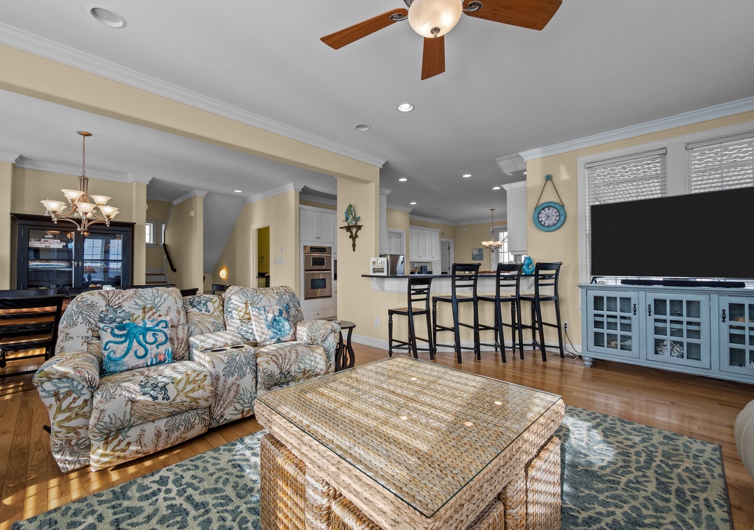 Your coastal-themed living space flows seamlessly into the kitchen, with comfortable seating and entertainment center perfect for family time.