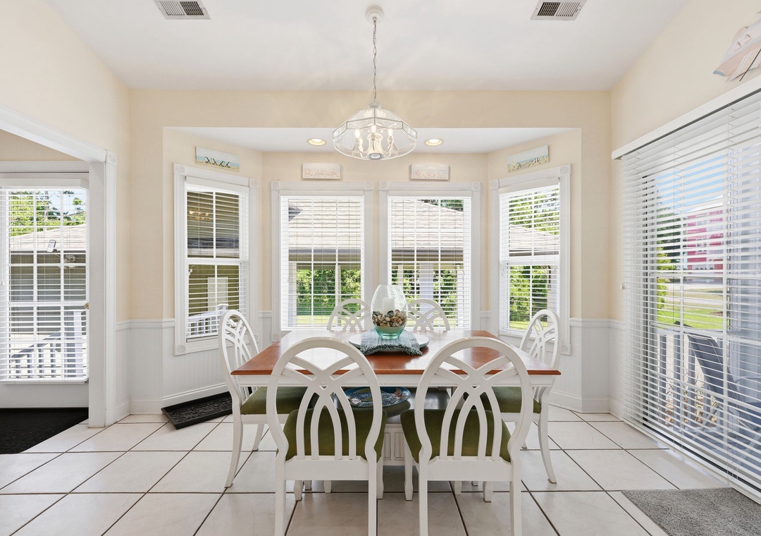 Gather around this bright dining area where natural light pours through bay windows, creating the perfect spot for your morning coffee or family meals together.