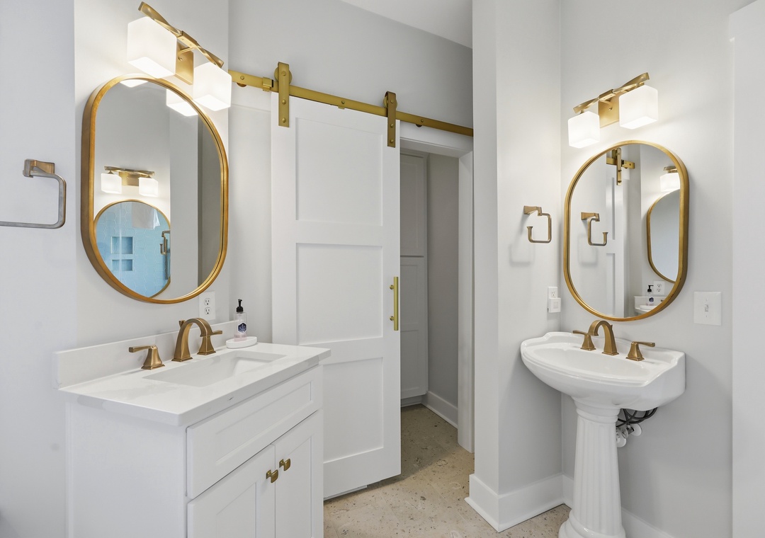 Step into your beautifully appointed bathroom, where elegant gold-framed mirrors, marble countertops, and warm lighting create a refined, spa-like retreat for your morning and evening routines.
