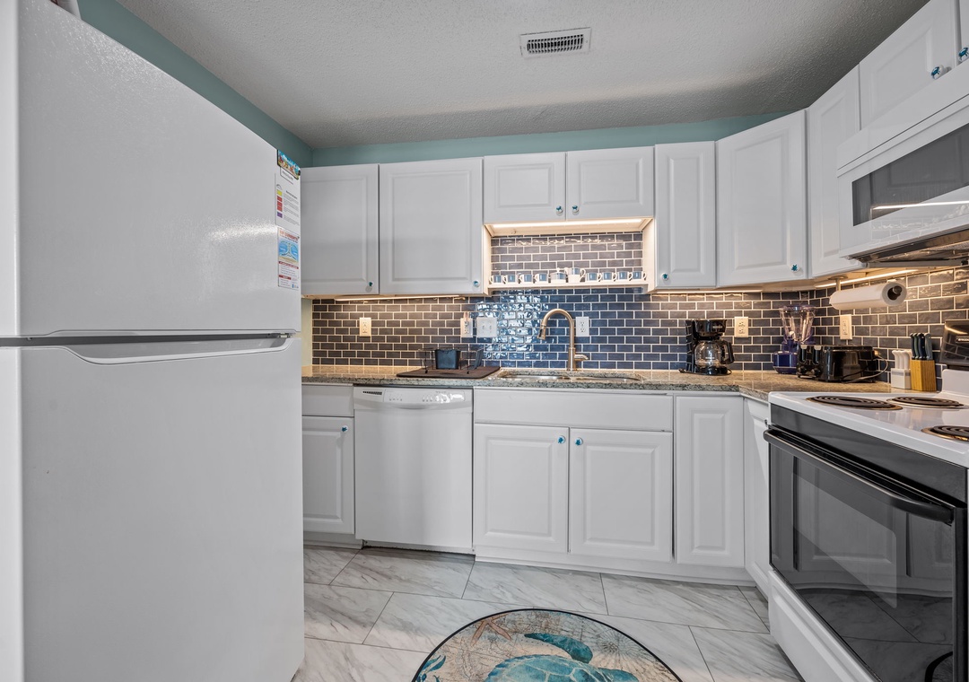 Your bright, fully equipped kitchen awaits with modern appliances and beautiful tile details.