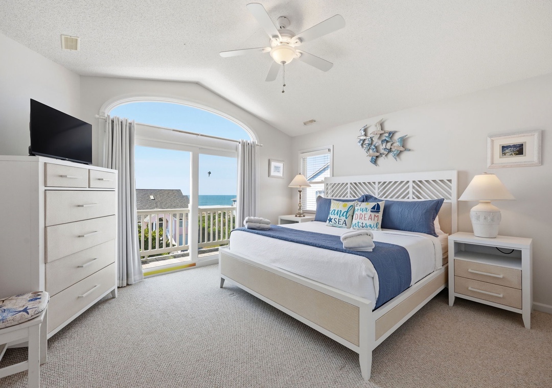 Wake up to stunning ocean views from your coastal retreat. This inviting bedroom features a plush bed with coastal accents, beach-inspired decor, and a private balcony overlooking the sea breeze.