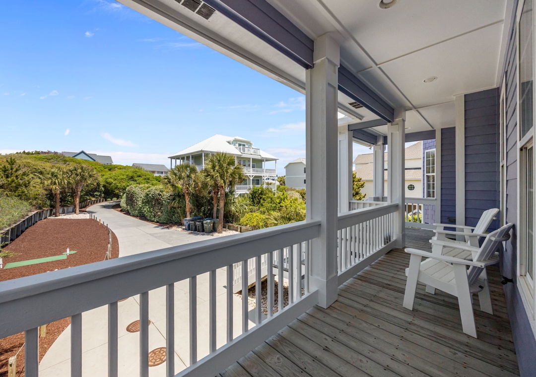 Unwind on your private covered balcony with comfortable seating, overlooking tropical landscaping and neighboring beach homes.