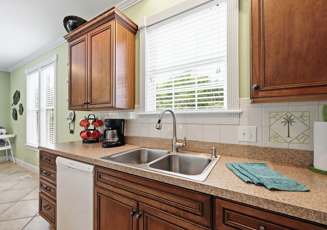 Your kitchen welcomes you with warm wood cabinetry, speckled granite counters, and a double sink. Enjoy tropical touches and plenty of natural light for cooking, with all the appliances you need.